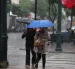 Personas se movilizan bajo la lluvia que sorprendió a la ciudad en horas de la tarde.
