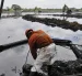 Fotografía de referencia de un empleado de la estatal Petróleos Mexicanos (Pemex) en medio de una extracción de crudo vertido durante un derrame de combustible.
