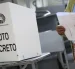 Ciudadana revisa su papeleta antes de ejercer el voto en un recinto electoral en Ecuador.