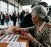Imagen simbólica de una adulta mayor comprando boletos con el descuento.