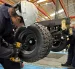 Un par de trabajadores cumplen su jornada en una fábrica de carros.