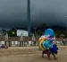 Fotografía referencial, vendedores caminan en una playa.