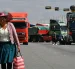 Una mujer quechua camina frente a vehículos de una caravana de transportistas para exigir el levante de los bloqueos de carreteras este lunes, en Cochabamba (Bolivia).