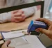 Referencial.Un funcionario estampa la aprobación en un trámite, mientras un solicitante espera la resolución en la oficina.
