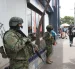 Dos militares resguardan una zona de afluencia de civiles en una ciudad.