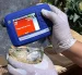 Una persona inspeccionando mercancía durante un operativo en el que decomisaron 30 kilos de presunta cocaína ocultos en piñas en Santo Domingo (República Dominicana).