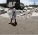 Una habitante de la aldea camina frente a escombros de casas destruidas en Cedeño, al sur de Honduras. El poblado lleva 30 años sufriendo el avance del mar.
