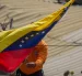 Un integrante de Protección Civil coloca la bandera de Venezuela en La Guaira tras los terremotos