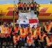 Personal de carga junto a un envío con la bandera de Panamá en un avión de DHL