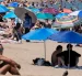 Turistas buscan sombra bajo sombrillas en playas europeas durante la ola de calor.