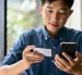 Uso de tarjeta y celular en una transacción digital, reflejo de operaciones que pueden generar errores de transferencia.