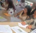 Una de las parejas firma el acta que oficializa su unión durante el matrimonio colectivo celebrado en Parque Samanes.