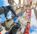 Dos personas hacen labor de mantenimiento en una torre donde se extrae petróleo.