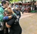 Familiares de una víctima de un tiroteo escolar guardan luto mientras los cuerpos de los fallecidos son introducidos en ambulancias en la escuela del distrito de Bang Kruai, provincia de Nonthaburi, el 7 de agosto de 2026.