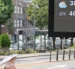 Un tablero digital muestra 38 °C en una calle de Pyongyang, mientras un transeúnte se protege del sol con sombrilla en plena ola de calor.