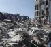 Personas caminan sobre los escombros de un edificio colapsado este lunes, en Cali (Colombia).