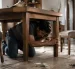 Una persona se protege bajo una mesa durante un sismo, siguiendo las recomendaciones básicas de seguridad.