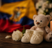 Un osito, unos zapatitos de bebé y una vela encendida simbolizan el duelo perinatal y la memoria de una vida que no llegó a nacer.