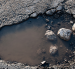 La vía Saracay-Portovelo presenta baches y deterioro mientras soporta el tránsito constante de volquetes con material mineralizado.