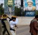 Personas armadas pasan junto a pinturas que representan a líderes hutíes fallecidos, expuestas en una valla en Saná, Yemen, el 7 de septiembre de 2026.