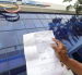 Una persona presenta su planilla de luz en CNEL.