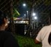 Unas mujeres miran a través de una valla durante una vigilia para exigir la liberación de los presos políticos venezolanos frente a la prisión El Rodeo I en Guatire.