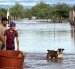 Personas cruzan en medio de una inundación causada por el paso de la tormenta tropical Polo en Guaymas al sur de Sonora (México).