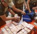 Integrantes de la Fuerza Especial de Lucha Contra el Crimen (FELCC) de Bolivia cuentan billetes que fueron encontrados en una ambulancia.