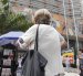 Una adulta mayor camina al pie del edificio del Instituto Ecuatoriano de Seguridad Social.