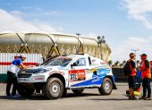 El piloto ecuatoriano Sebastián Guayasamín (i) junto al auto con el que competirá en el rally Dakar a desarrollarse en Arabia Saudita.