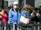 Passengers use face masks as a precautionary measure against the spread of the new coronavirus, COVID-19, at El Dorado international airport in Bogota on March 17, 2020.  Quarantine, schools, shops and borders closed, gatherings banned, are the main measures being taken in many countries across the world to fight the spread of the novel coronavirus. / AFP / Juan BARRETO

 COLOMBIA-HEALTH-VIRUS
