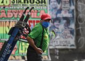 Un hombre con tapabocas trabaja en el Mercado Mayorista de Frutas de Lima (Perú). Casi sin recursos y sin otras opciones, Perú comenzará formalmente a reabrir su cuarentena.