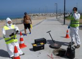 ASHKELON. Técnicos de la firma israelí Kando extraen muestras de aguas residuales de una boca de inspección cerca de la playa de esta ciudad balnerario.