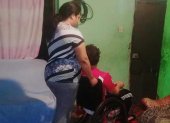 Una madre moviliza a su hijo que tiene discapacidad.