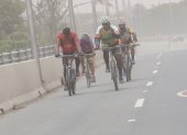 Ciclistas conducen en medio de las partículas del Sangay, en Guayaquil.