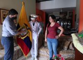 Anthony Santillán Mora, abanderado de la Academia Naval Guayaquil, recibe en su casa la bandera por parte de un directivo de la plantel. A su lado está su mamá.