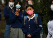 Estudiantes retornan a las aulas con mascarillas y distanciamiento físico.