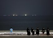 Instante. En la imagen, varias mujeres al anochecer en la playa de Katara, en Doha.
