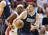 El alero del Miami Heat, Jimmy Butler (i), defiende al escolta de los Dallas Mavericks, Luka Doncic (d).