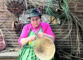 Arte. Una indígena confecciona una cesta artesanal.