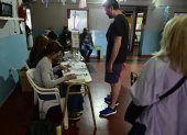 Personas asisten hoy, en un centro de votaciones en Buenos Aires (Argentina). Sergio Massa y Javier Milei son los dos candidatos del balotaje argentino y al final de la jornada uno de ellos será elegido como el futuro presidente del país.