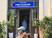 Una mujer caminando frente a la entrada del departamento de tuberculosis respiratoria del Hospital Nacional del Pulmón en Hanoi.