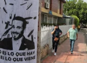 Personas caminan junto a un cartel alusivo al ultraderechista Abelardo de la Espriella.