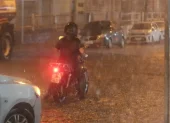 Vehículos circulan por una de las calles afectadas por la acumulación de agua en el norte de Guayaquil.