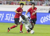John Yeboah de Ecuador (C) cae ante la marca de Kim Bong-soo (d) y Kim Tae-hyeon de Corea del Sur el jueves pasado.