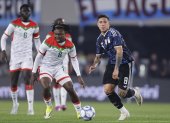 Enzo Fernández (d) de Argentina disputa el balón con Alain Kanté de Burkina Faso.