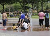 Decenas de personas aprovechan las fuentes públicas para aplacar un poco el calor de la urbe.