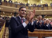 El socialista Pedro Sánchez aplaude después de ganar una votación parlamentaria en España.