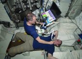El astronauta Tom Marshburn realiza una exploración del cuello del astronauta Chris Hadfield en la ISS.