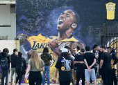 Fanáticos de Kobe Bryant cerca a una imagen de su ídolo, fallecido en un accidente aéreo.